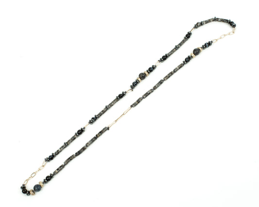 Beaded necklace with black and gold beads on a white background